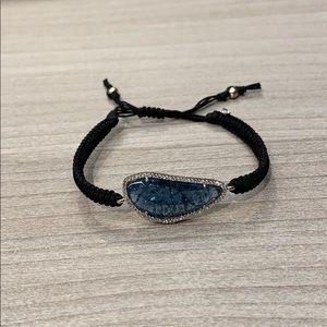 Braided cord bracelet with large blue stone .